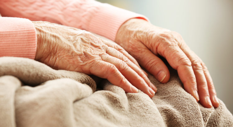 Hands of adult woman on light background, closeup