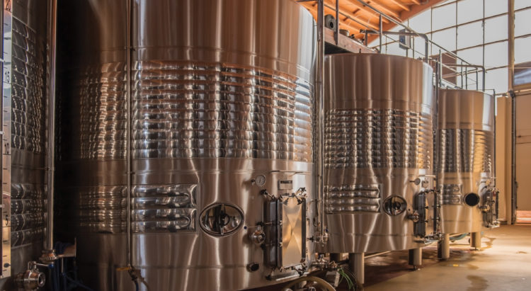 Modern wine fermenters in Extremadura, Spain A modern commercial wine making bodega in Extremadura, Spain. The wine is fermented in huge stainless steel tanks where the process can be carefully controlled